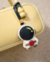 Close-up of the astronaut charm — hand-cut and hand-stitched panels of French Alran goatskin. Every layer by hand.