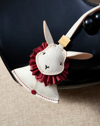Close-up of the rabbit charm — hand-cut and hand-stitched panels of French Alran goatskin. Every layer by hand.