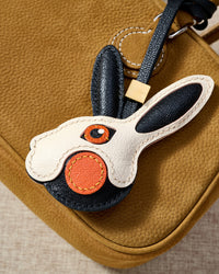 Close-up of the rabbit charm — hand-cut and hand-stitched panels of French Alran goatskin. Every layer by hand.