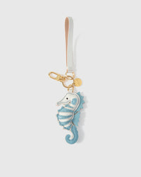 Both editions of the blue seahorse — leather strap loop for bags, or 18K gold-plated keychain clip.