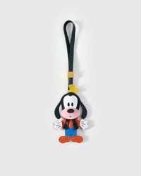 Goofy-style charm handmade from French Alran genuine goatskin — full-body, black head with long ears, white face with pink muzzle, green hat, orange sweater vest, blue shorts, orange shoes, black leather strap. Three days by hand. Arrives in luxury gift packaging. Designed in Amsterdam.