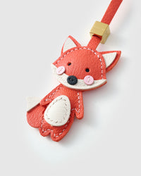 Close-up of the fox charm — hand-cut and hand-stitched panels of French Alran goatskin. Every layer by hand.
