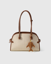Caramel whale charm on a bag, side angle — loved by thousands of ocean lovers. Real French leather, 3 days by hand.