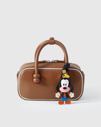 Goofy charm on a bag, side angle — loved by thousands of character-charm fans. Real French leather, 3 days by hand.