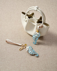 Close-up of the blue seahorse — hand-stitched dorsal ridge, heart-shaped chest fin, curled leather tail. Every panel by hand.