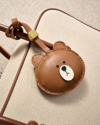 Close-up of the cuddly bear charm — hand-cut and hand-stitched panels of French Alran goatskin. Every layer by hand.