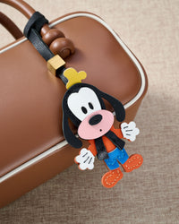 Goofy charm styled on a bag, front — a small, specific piece that turns a simple bag into a personal one.