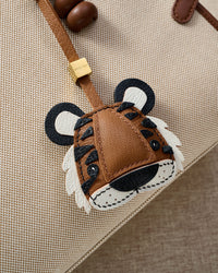 Close-up of the tiger charm — hand-cut and hand-stitched panels of French Alran goatskin. Every layer by hand.