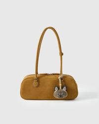 Tonkinese cat charm styled on a mustard-yellow suede top-handle bag, front — real French leather, made to be carried on the bag that sees every day.