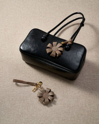 Close-up of STICKYZOO Daisy Bag Charm — full-grain French Alran goatskin from Tarn, France. 3d folded daisy petals. 3-day handmade piece.
