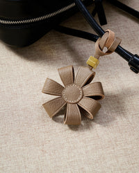 STICKYZOO Daisy Bag Charm — hand-cut, hand-stitched 3D folded daisy petals in French Alran goatskin. Designed in Amsterdam.