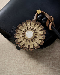 Close-up of STICKYZOO Sunflower Charm — full-grain French Alran goatskin from Tarn, France. Layered sunflower petals with white centre. 3-day handmade piece.