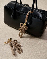 Close-up of the rabbit charm — hand-cut and hand-stitched panels of French Alran goatskin. Every layer by hand.