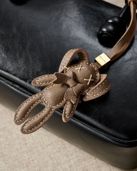 RABBIT CHARM charm styled on a bag — a small, specific piece that turns a simple bag into a personal one.