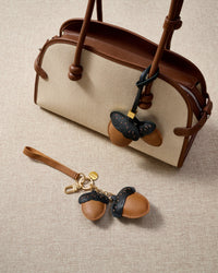Close-up of STICKYZOO Acorns Charm — full-grain French Alran goatskin from Tarn, France. Twin acorn pair with dash stitching. 3-day handmade piece.