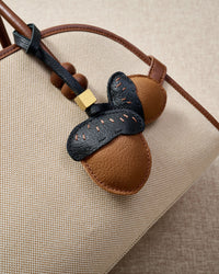 STICKYZOO Acorns Charm — hand-cut, hand-stitched twin acorn pair with dash stitching in French Alran goatskin. Designed in Amsterdam.