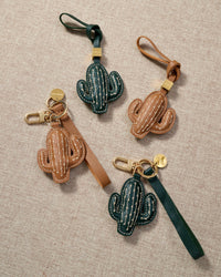 Close-up of STICKYZOO Cactus Charm — full-grain French Alran goatskin from Tarn, France. Saguaro silhouette with cream cross-stitch. 3-day handmade piece.