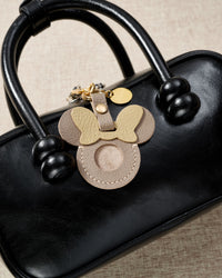 Taupe Mickey AirTag holder — precision-cut cavity fits one Apple AirTag snugly. Real French Alran goatskin, stitched by hand.