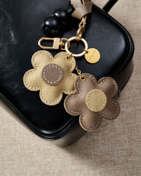 STICKYZOO Twin Flowers Charm — hand-cut, hand-stitched twin five-petal blooms on gold keychain in French Alran goatskin. Designed in Amsterdam.