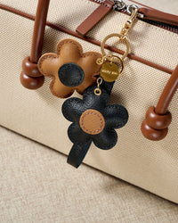 STICKYZOO Twin Flowers Charm — hand-cut, hand-stitched twin five-petal blooms on gold keychain in French Alran goatskin. Designed in Amsterdam.
