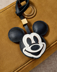 Mickey charm styled on a bag, front — a small, specific piece that turns a simple bag into a personal one.