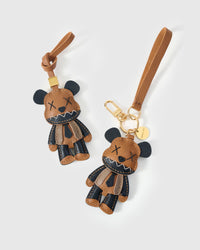 Both editions of the violent bear charm — leather strap loop for bags, or 18K gold-plated keychain clip.