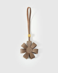 STICKYZOO Daisy Bag Charm in warm taupe French Alran goatskin — folded dimensional petals with tonal centre disc, 18K gold-plated hardware. 3-day handmade piece.