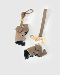 Both editions of the elephant charm — leather strap loop for bags, or 18K gold-plated keychain clip.