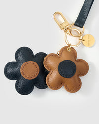 Close-up of STICKYZOO Twin Flowers Charm — full-grain French Alran goatskin from Tarn, France. Twin five-petal blooms on gold keychain. 3-day handmade piece.
