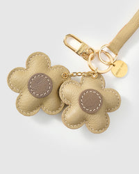 Close-up of STICKYZOO Twin Flowers Charm — full-grain French Alran goatskin from Tarn, France. Twin five-petal blooms on gold keychain. 3-day handmade piece.