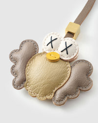 Both editions of gold Hootie — leather strap loop for bags, or 18K gold-plated keychain clip.