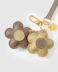 Close-up of STICKYZOO Twin Flowers Charm — full-grain French Alran goatskin from Tarn, France. Twin five-petal blooms on gold keychain. 3-day handmade piece.