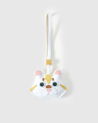 Light Silver Tabby cat charm handmade from French Alran genuine goatskin — pure white body, soft yellow markings, blue eyes, copper-heart nose, white leather strap. Three days by hand. Arrives in luxury gift packaging. Designed in Amsterdam.