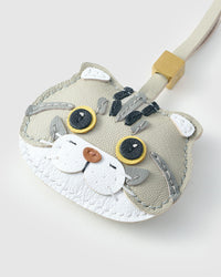 Tight close-up of the Scottish Fold face — folded ears, amber eyes in real leather, darker forehead stripe, stitched whiskers. Every panel by hand.