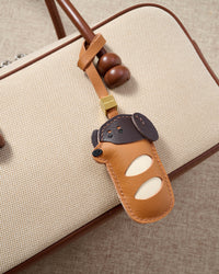 Dachshund Sausage Pup leather bag charm shown in both attachment options — handmade French Alran goatskin, dual attachment for bags or keys. STICKYZOO Amsterdam design.