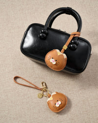 Tight close-up of the bread kitty charm face — every detail in real French Alran leather, layered and stitched by hand.