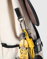 STICKYZOO Skater Pup Backpack hardware detail showing silver carabiner clip, leather straps, and charm attachment on blue fabric