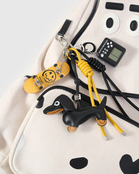 STICKYZOO Skater Pup Backpack charm bundle close-up showing brown leather dachshund, football charm, and New York City tag