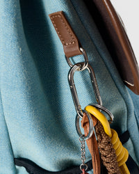 STICKYZOO Capster Backpack hardware detail showing silver carabiner, skateboard charm, and charm attachment on dalmatian fabric