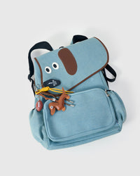 STICKYZOO Capster Backpack top-down view showing white dalmatian-spotted body, dachshund face flap, and full charm set