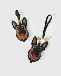 German Shepherd leather bag charm in both attachment formats — leather strap with engraved 18K gold cube and 18K gold-plated keychain clip with engraved tag. Handmade French Alran goatskin.