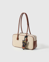 Handmade German Shepherd leather bag charm on a cream canvas handbag — French Alran goatskin from a tannery founded in 1903 in Tarn, France. STICKYZOO collectible.