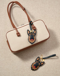 German Shepherd leather bag charm shown in both attachment options — handmade French Alran goatskin, dual attachment for bags or keys. STICKYZOO Amsterdam design.