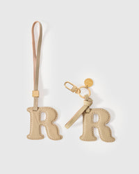 Wear the R initial charm on a bag with the leather strap loop, or clip it to keys with the 18K gold-plated keychain clip. Two ways to carry one gift.