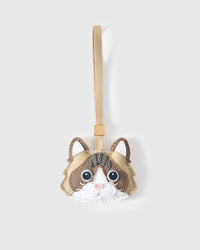 Latte Paws Ragdoll cat charm handmade from French Alran genuine goatskin — latte-cream body, deep brown markings, vivid blue eyes, pink nose, white face mask, beige leather strap. Three days by hand. Arrives in luxury gift packaging. Designed in Amsterdam.