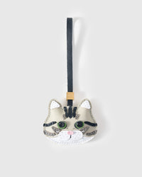 American Shorthair Silver Tabby cat charm handmade from French Alran genuine goatskin — light silver-ivory body, charcoal tabby stripes, green eyes, white chin, pink nose, black leather strap. Three days by hand. Arrives in luxury gift packaging. Designed in Amsterdam.