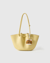 Orange tabby styled on a pastel-yellow tote bag, front view — the small specific piece that makes the bag feel personal.