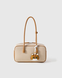 The British Shorthair charm styled on a cream canvas-and-tan top-handle bag — a small piece that turns a simple bag into a personal one.