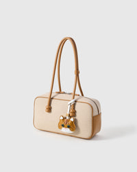 Ginger British Shorthair charm on a cream canvas-and-tan top-handle bag, side angle — loved by thousands of cat people. Real French leather, 3 days by hand.