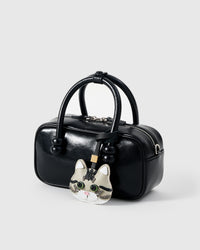 Silver Tabby American Shorthair styled on a black top-handle bag, side angle — Real French leather, 3 days by hand.